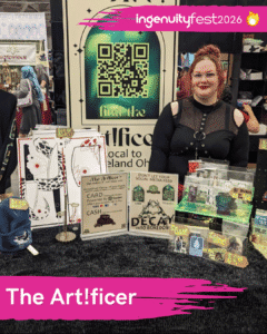 The Art!ficer - IngenuityFest Vendor - artist in booth with merchandise.